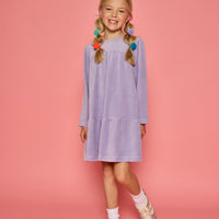 Model can be seen wearing a long sleeve lilac velour dress. Dress features button closure at back for a relaxed but secure fit.