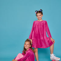 Model can be seen wearing long sleeve velour magenta top paired back with a pair of bubblegum pink corduroy pants. Top features button closure at back and pants have pockets as well. Coordinating back as well with our long sleeve magenta velour dress.
