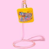 Colorful confetti hair clips on a yellow card.