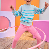 Tween model can be seen wearing an aqua stripe sweater paired back with leggings in a hot pink color to complete the vibrant look.
