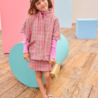 Model can be seen wearing tweed skort in magenta/pink/green plaid pattern paired back perfectly with the cape in the matching print and material.