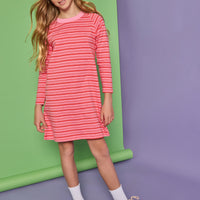Model can be seen wearing a red and pink stripe knit dress. Dress features a thick pink neckline for an elevated look.