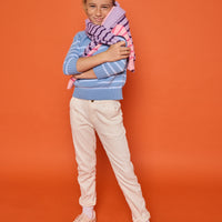 Model can be seen wearing our knit blue and light blue stripe sweater paired back with white jeans to complete the look. Model also has our other sweaters in purple/dark purple stripe and pink/hot pink stripe for a fun and fresh look.