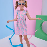 Model can be seen wearing a woven pink/light blue floral dress that features two cutout features on the sides of the dress to give it an elevated/big girl feel.