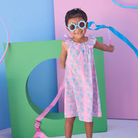 Model can be seen wearing a blue and pink floral woven dress that features an elastic scallop neckline detail to elevate the look.