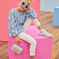 Model can be seen wearing a light blue shirt that features white dobby detailing and white lace stripes which pairs back perfectly with ivory jeans to complete the look.