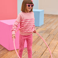 Tween model seen wearing a striped light pink and hot pink sweater paired back with leggings in a fun fall print.
