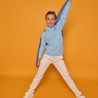 Model can be seen wearing a long sleeve ribbed knit turtleneck in a light blue color paired back with basic white jeans to complete the look.
