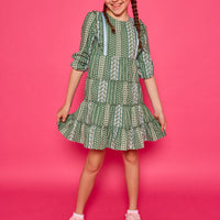 Model can be seen wearing woven dress in a green/blue/white floral. Dress features four tier detail to elevate the dress.