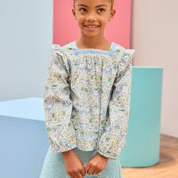 Model can be seen wearing an aqua quilted knit skort in a trellis pattern for a soft an elevated look, which pairs back perfectly with the long sleeve floral aqua/blue/yellow/green floral top.