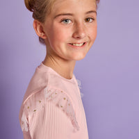 Model can be seen wearing a bubblegum pink ribbed knit long sleeve t-shirt with tulle sparkle star fabric at top of sleeves for elevated look.