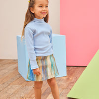 Model can be seen wearing a multi stripe wool skort in a brown/blue/aqua pattern paired back with a ribbed turtleneck in light blue to complete the look.
