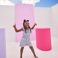 Girls/Tween woven romper in a beautiful lilac/blue/red floral pattern. Romper features an elastic waistband, scalloped elastic neckline with a beautiful aqua embroidered edge, and also has pockets.