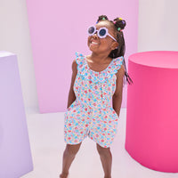 Girls/Tween woven romper in a beautiful lilac/blue/red floral pattern. Romper features an elastic waistband, scalloped elastic neckline with a beautiful aqua embroidered edge, and also has pockets.
