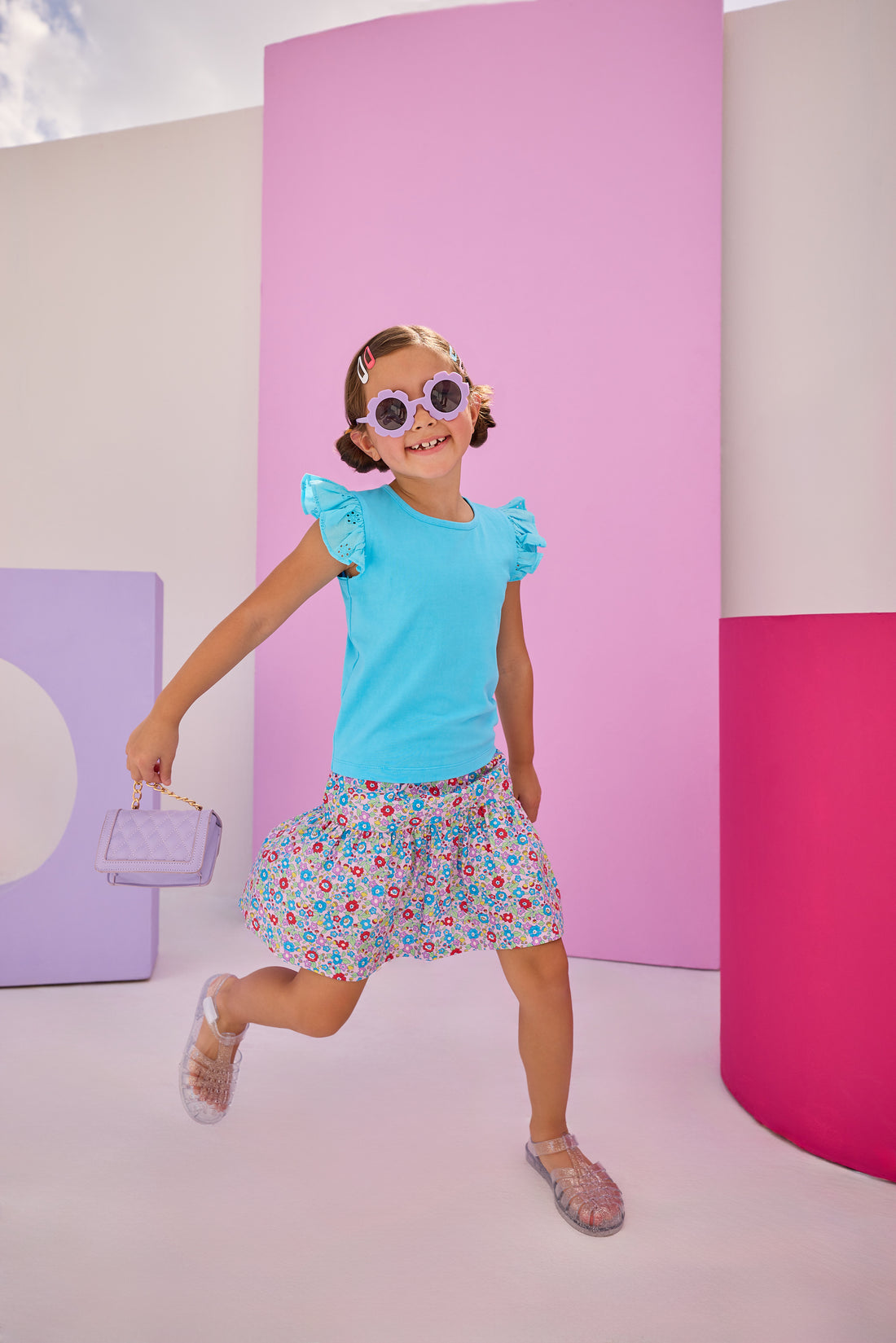 Girls/Tween model can be seen wearing a knit eyelet angel sleeve tank in aqua that pairs back perfectly with this skort in a lilac, aqua, red floral pattern to complete the look.