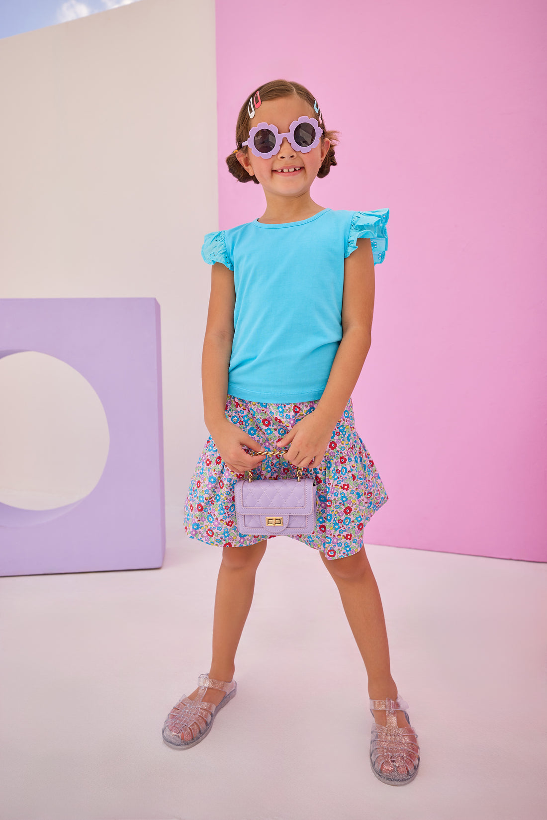 Girls/Tween model can be seen wearing a knit eyelet angel sleeve tank in aqua that pairs back perfectly with this skort in a lilac, aqua, red floral pattern to complete the look.