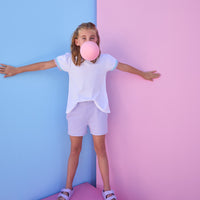 Model can be seen wearing a white knit tee that has a aqua/lavender ric rac detail at cuffs of sleeves. Shirt pairs back perfectly with knit lavender shorts to complete the look.