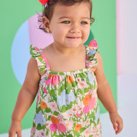 Baby model can be seen wearing a two piece woven bloomer set in a beautiful green/pink/orange/light blue floral print. Top features button closure at end of straps along back, and bottoms are easy pull on style for a secure but comfy fit.