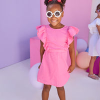 Model can be seen wearing a hot pink woven embroidery material. Dress features big angel sleeve detail and almost full open back for an elevated look.