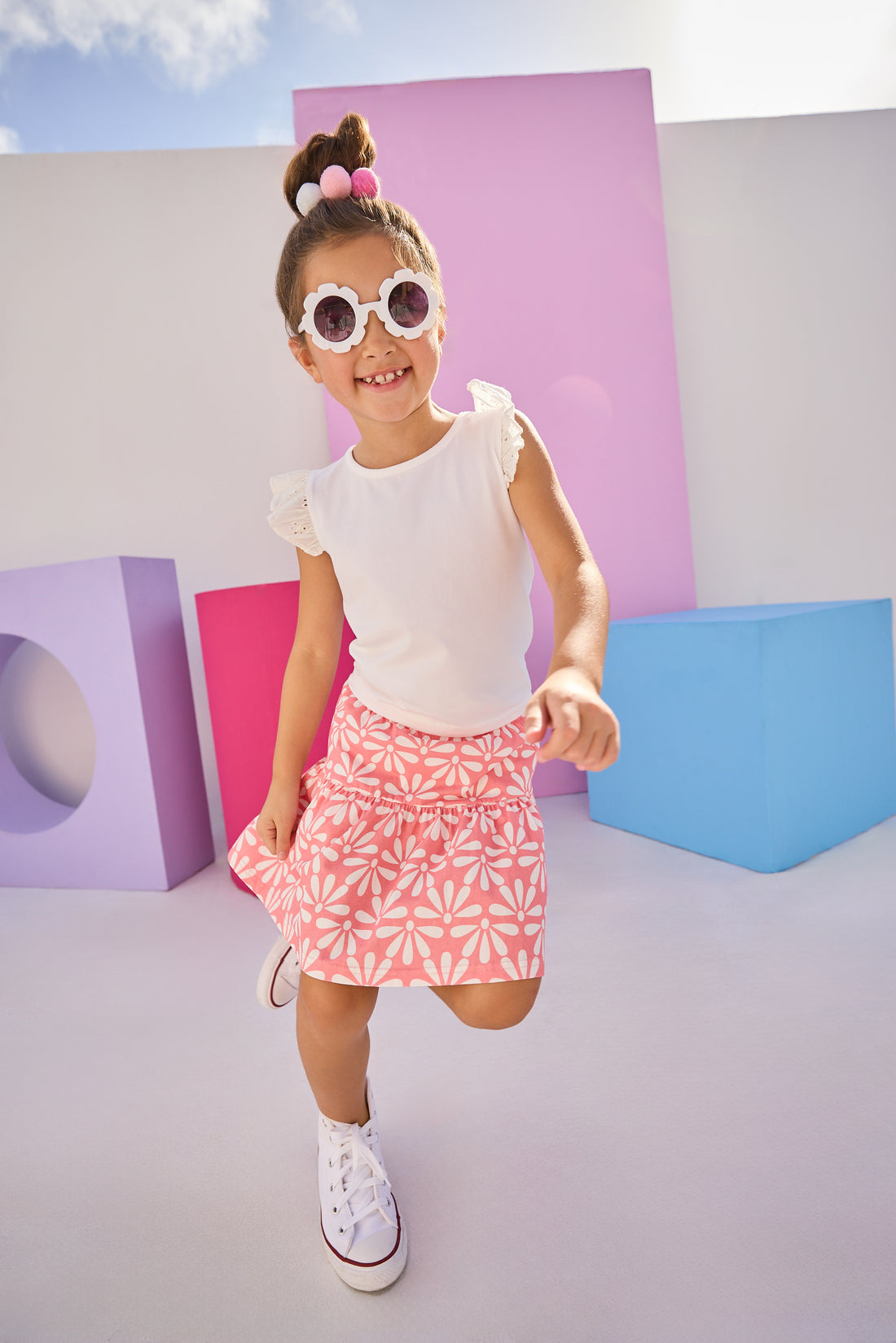 Girls/Tween model can be seen wearing a knit eyelet angel sleeve tank that pairs back perfectly with this skort in a salmon and white floral pattern.
