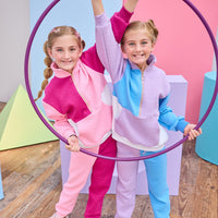 Models can be seen wearing matching color block jogger sets in lilac/aqua and cranberry/pink. Sets are made of a knit material and feature gold quarter zip detail and joggers have adjustable tie waists for a relaxed and comfy fit.