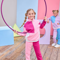 Model can be seen wearing a matching color block set in pink/cranberry/and white. Pullover features a gold quarter zip zipper detail and large front pocket for a relaxed but secure fit. Pullover matches back perfectly to the joggers, and continues with the color block with a pink pant leg and an cranberry pant leg.