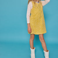 Model can be seen wearing a jumper in a yellow/white floral print. Jumper is made of a corduroy material and has a quarter zip zipper down the front. Paired nicely with our essential scallop tee to complete the look.