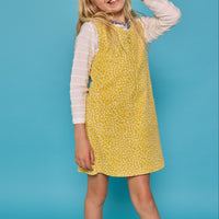 Model can be seen wearing a jumper in a yellow/white floral print. Jumper is made of a corduroy material and has a quarter zip zipper down the front. Paired nicely with our essential scallop tee to complete the look.