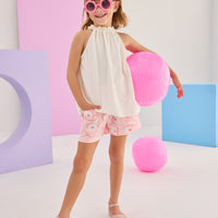 Girls/Tween woven shorts in a light pink and white floral print. Shorts have an elastic waistband and pockets in the front for a comfy and secure fit. Model can be seen pairing these shorts with our sleeveless tank top in a gorgeous white pointelle fabric.