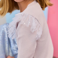 Tween model seen wearing ribbed long sleeve shirt with a tulle angel sleeve detail in gray with silver stars.