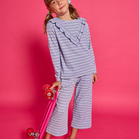 Model can be seen wearing a blue/white/sparkle striped long sleeve knit shirt. Shirt features a v-ruffle detail across bust for an elevated look.