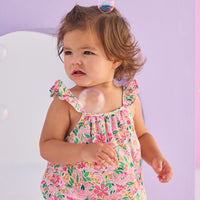 Baby girl woven bubble in a hot pink/yellow/green floral pattern. Bubble features button closures along back and stride and strappy angel sleeves for an elevated look.