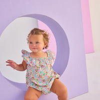 Baby girl woven bubble in a gorgeous pale yellow/pink/green floral pattern. Bubble features scallop neckline and also has button snap closures along stride for easy put on access.