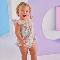 Baby girl woven bubble in a gorgeous pale yellow/pink/green floral pattern. Bubble features scallop neckline and also has button snap closures along stride for easy put on access.
