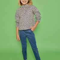 Model can be seen wearing a long sleeve woven top in a blue/cream floral print. Top features button closure packet down bust and smocking detail at sleeves for an elevated look. Paired back with our dusty blue corduroy pants to complete the look.