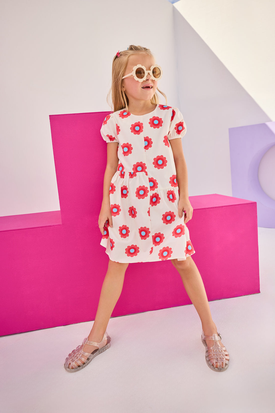 Model can be seen wearing woven asymmetrical cut dress in white with big red/blue flowers printed on it. The cuffs at sleeves are elastic and there is a zipper along back for a relaxed but secure fit perfect for spring and summer.