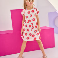 Model can be seen wearing woven asymmetrical cut dress in white with big red/blue flowers printed on it. The cuffs at sleeves are elastic and there is a zipper along back for a relaxed but secure fit perfect for spring and summer.