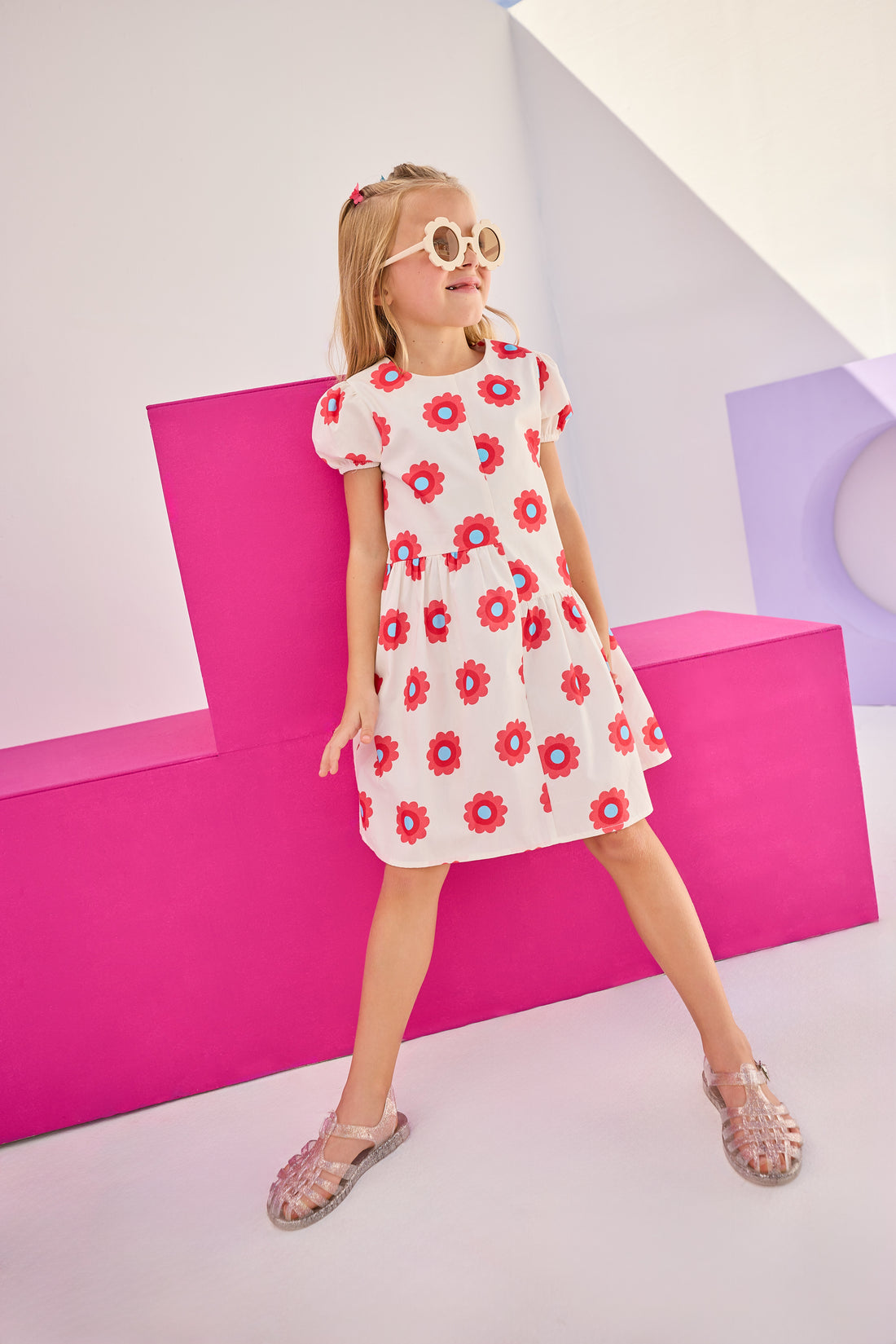 Model can be seen wearing woven asymmetrical cut dress in white with big red/blue flowers printed on it. The cuffs at sleeves are elastic and there is a zipper along back for a relaxed but secure fit perfect for spring and summer.