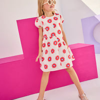 Model can be seen wearing woven asymmetrical cut dress in white with big red/blue flowers printed on it. The cuffs at sleeves are elastic and there is a zipper along back for a relaxed but secure fit perfect for spring and summer.