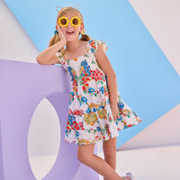 Model can be seen wearing woven dress with multi colored floral arrangement. Dress features angel sleeves and ruching at bust for a comfy and airy fit perfect for spring and summer.