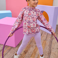 Tween model can be seen in a pink floral top paired back with our soft and stretchy lilac leggings.
