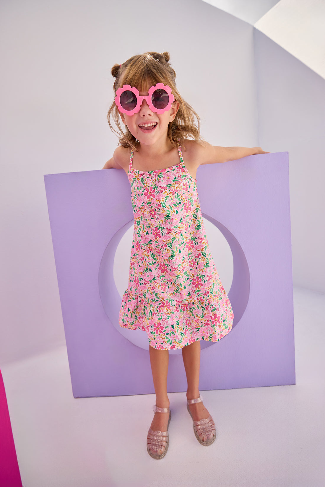 Model can be seen in woven dress with thin straps in a hot pink/yellow/white floral pattern. Dress is made up of a lightweight woven material for a perfect spring/summer dress.