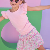 Model can be seen wearing a light pink knit short sleeve top that features eyelet detail on the angel sleeves. Top can be paired back with many bottoms in the line, as it is a solid pink shirt, easy to mix and match.