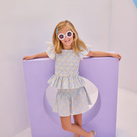 Model can be seen wearing gorgeous woven top that has a ruching feature across middle of top. Top is made of yellow and white flowers printed on a light blue background and also features angel sleeves to complete the look. Paired back perfectly with our shirred circle skirt in the same print for a complete set.