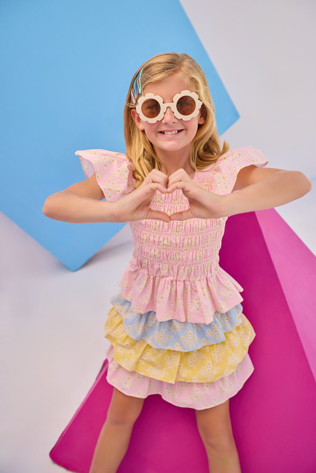 Model can be seen wearing woven three tiered skort in a blue/pink/yellow floral pattern. Skort features each tier with a different color arrangement, elastic waistband, built in shorts, and fixed ties for a relaxed but secure fit. Paired back perfectly with our India top in the same pink floral print to complete the look.