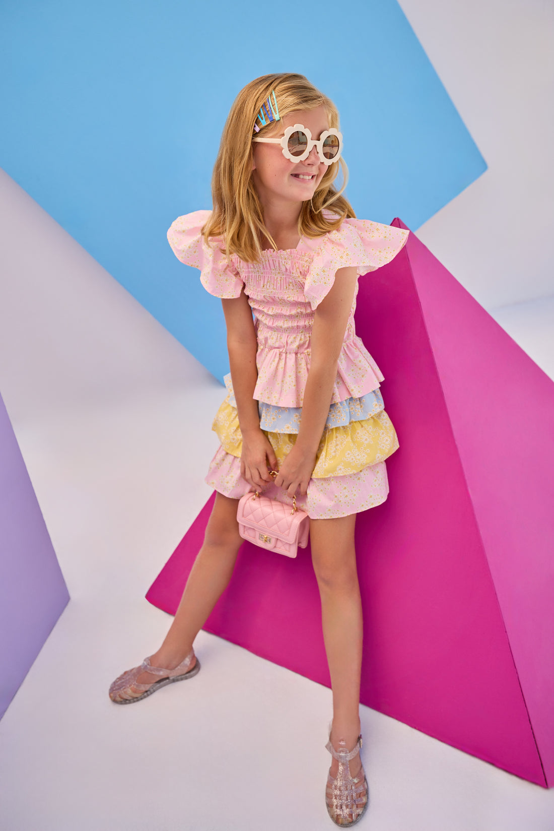 Model can be seen wearing woven three tiered skort in a blue/pink/yellow floral pattern. Skort features each tier with a different color arrangement, elastic waistband, built in shorts, and fixed ties for a relaxed but secure fit. Paired back perfectly with our India top in the same pink floral print to complete the look.