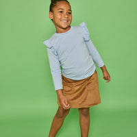 Model can be seen wearing a long sleeve blue and white strip knit top that features a fun ruffle detail at sleeve. Pair it back with our brown faux suede skort that features built in shorts and pockets in the front for an elevated look.