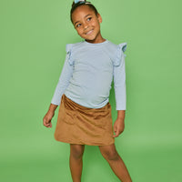 Model can be seen wearing a long sleeve blue and white strip knit top that features a fun ruffle detail at sleeve. Pair it back with our brown faux suede skort that features built in shorts and pockets in the front for an elevated look.