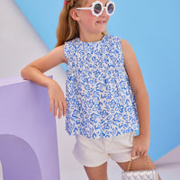 Model can be seen wearing Girls/Tween sleeveless woven top in a blue and white floral print. Top features ruching at the bust and fans out for a relaxed comfy fit. Pair back perfectly with ivory denim shorts to complete the look.