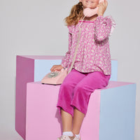 Tween girls square neck, three quarter sleeves with angel sleeve ruffles in a hot pink floral print paired with cropped velour pants in magenta.
